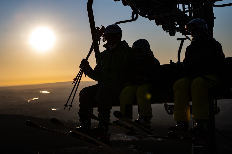  Wintersportler sitzen im Hexenritt-Sessellift auf dem Wurmberg. Die Skigebiet im Harz ist seit dem Sonnenaufgang geöffnet.