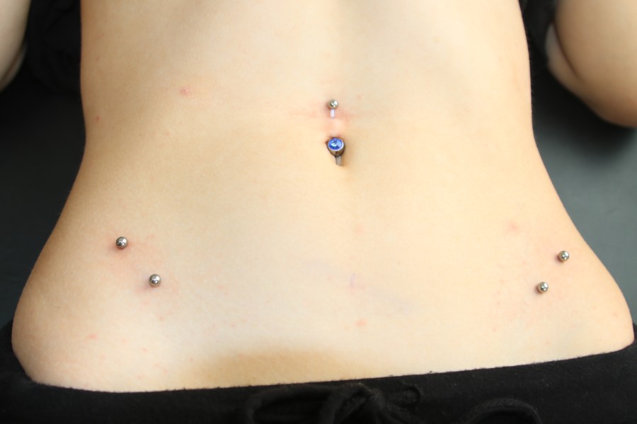 Ein Bauchnabelpiercing und zwei Surface.