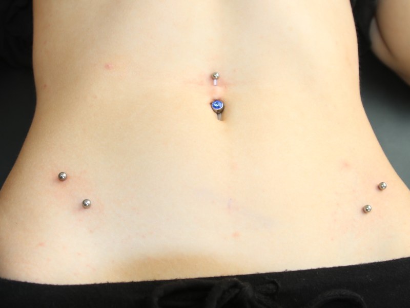 Ein Bauchnabelpiercing und zwei Surface., Janna Ansorge ist seit 2010 Piercerin in Braunschweig., Carsten Bergmeyer arbeitet schon seit 20 Jahren als Piercer.