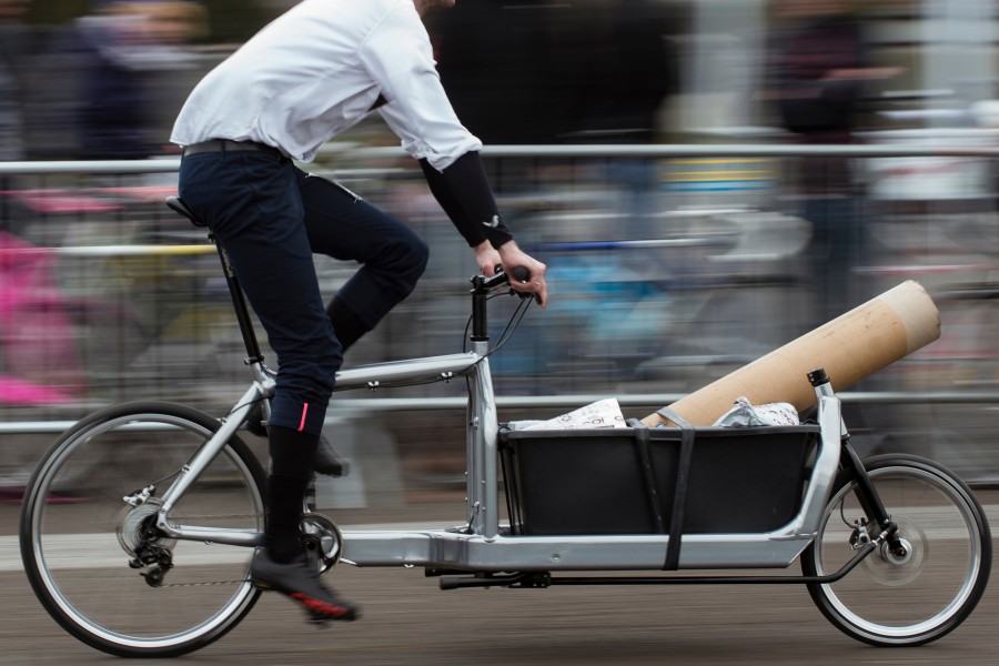 Mann fährt auf einem Lastenfahrrad