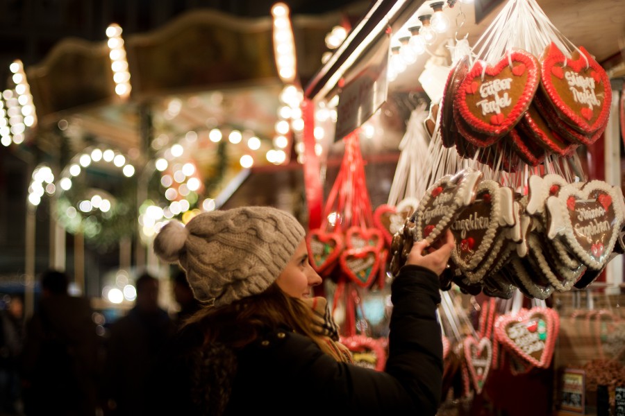 Frau schaut sich auf dem Weihnachtsmarkt Lebkuchenherzen an