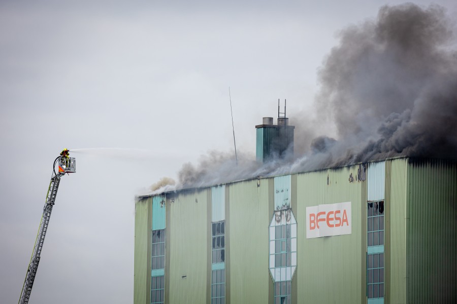 Feuerwehrleute löschen von einer Drehleiter aus den Brand einer Industriehalle in Hannover.