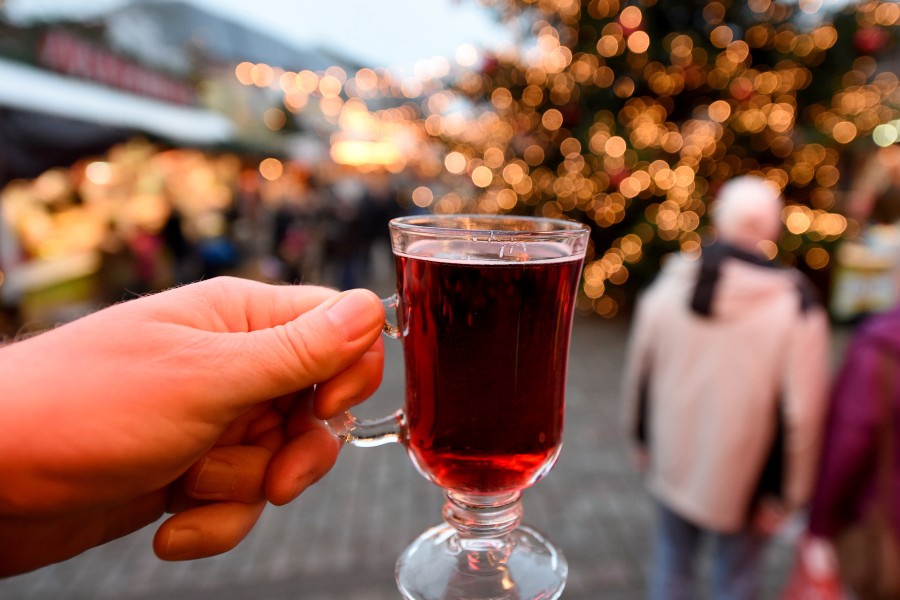 Eine Frau hält ein Glas Glühwein auf einem Weihnachtsmarkt (Symbolbild).