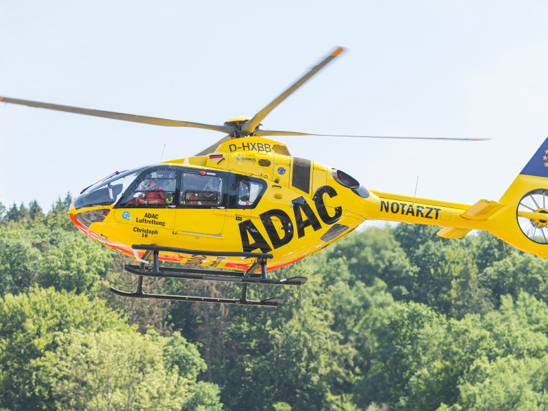Rettungshubschrauber fliegt über Bäume