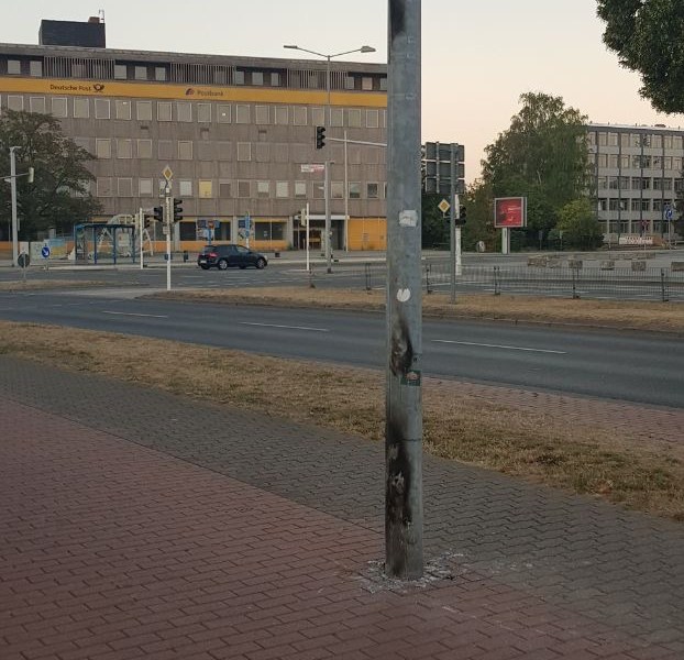 Abgebranntes Parteiplakat steht gegenüber vorm Rathaus