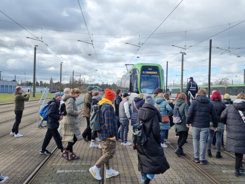 Fans auf dem Weg zu einem ganz besonderen Konzert in der Straßenbahn.