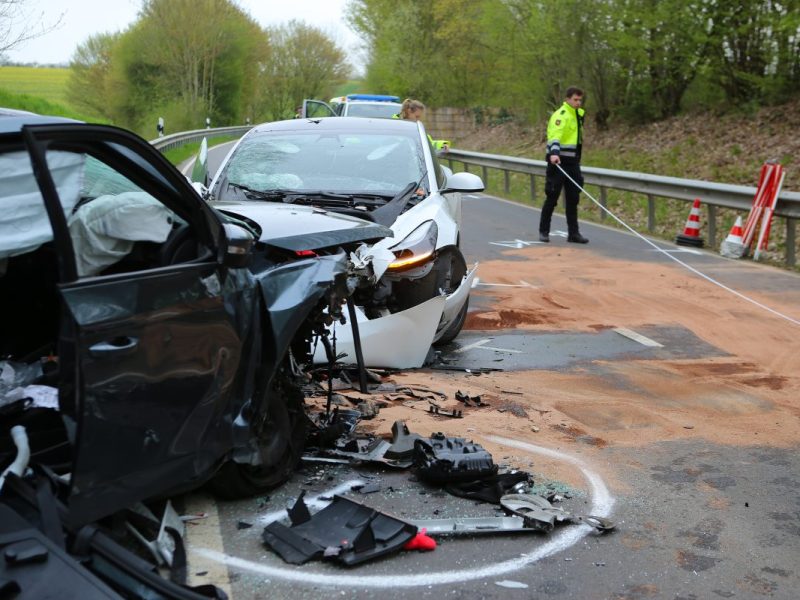 Zwei Fahrzeugwracks stehen auf der Landesstraße 569. Bei dem Unfall in der Gemeinde Gleichen im Landkreis Göttingen ist eine Frau ums Leben gekommen. Zwei Männer wurden verletzt.