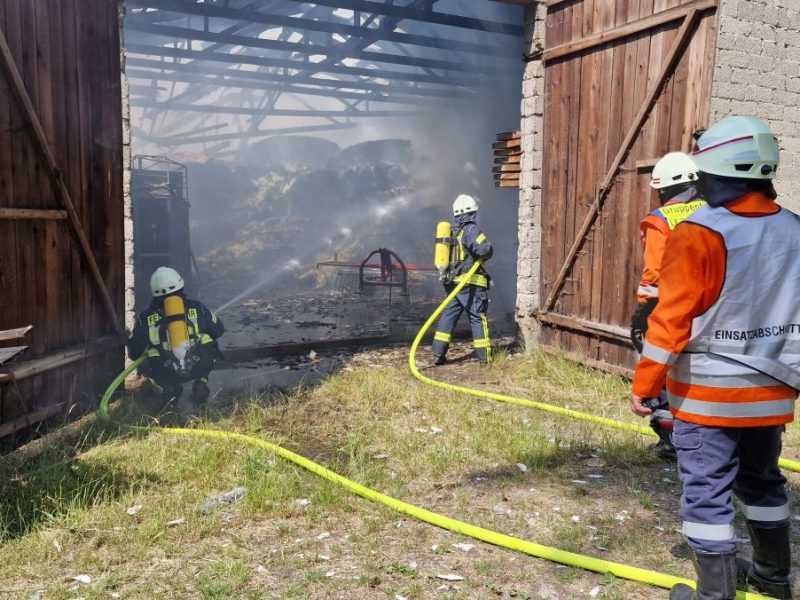 Die Feuerwehr löscht einen Brand in einer Scheune