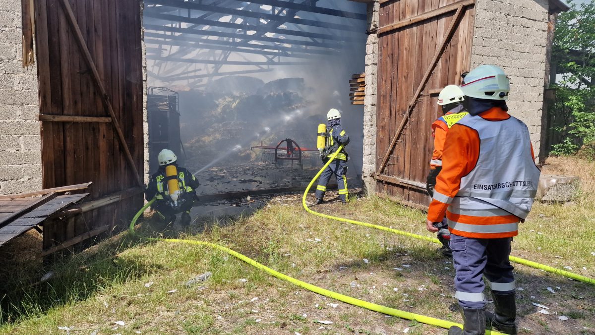 Die Feuerwehr löscht einen Brand in einer Scheune