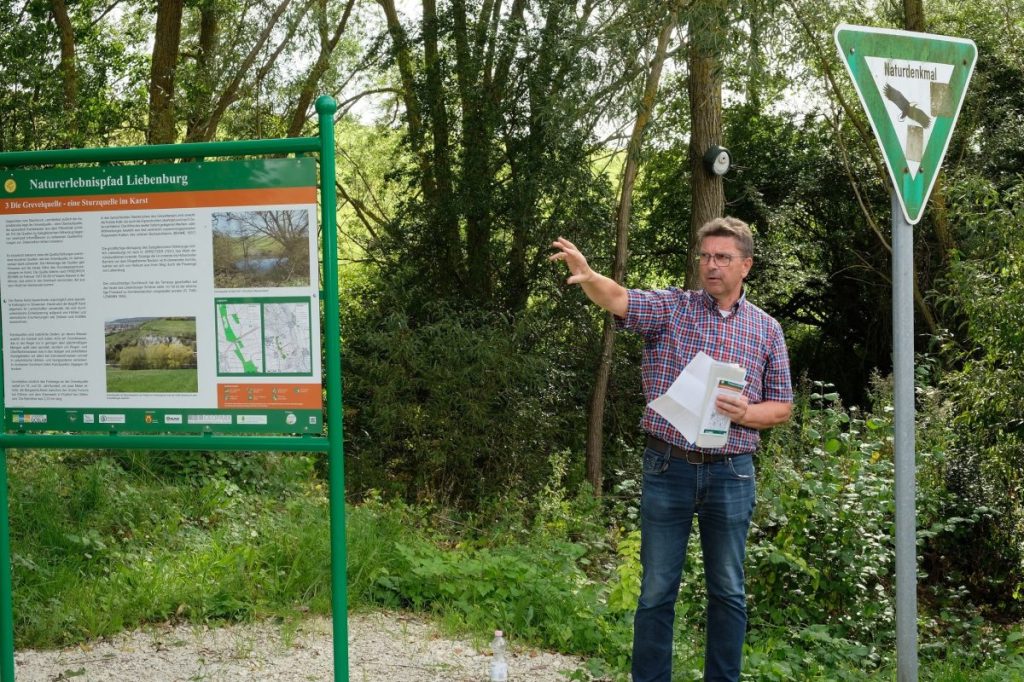 Projektverantwortlicher Rainer Schlicht erläutert die Station an der Grevelquelle. 