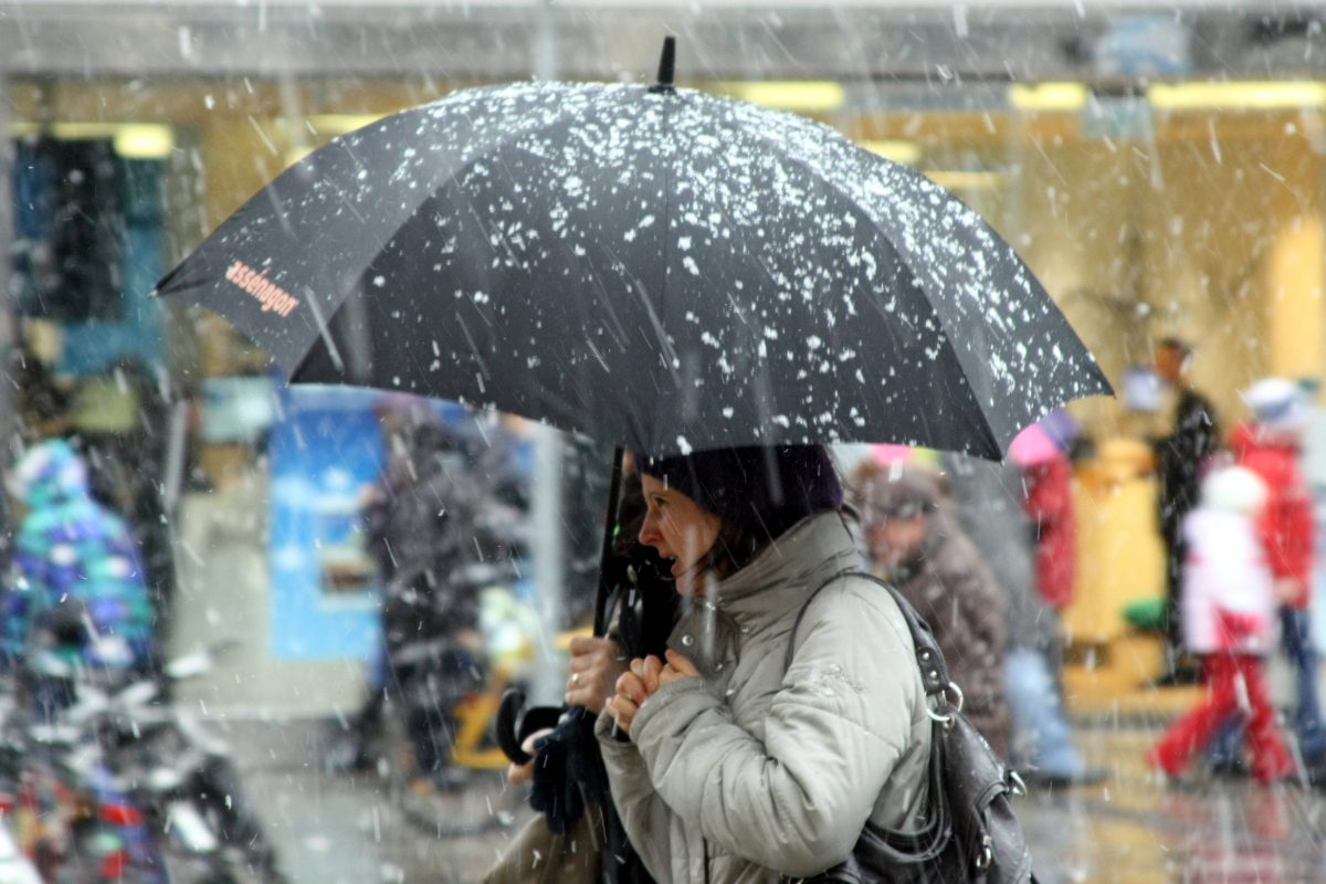 Frau mit Regenschirm im Schnee