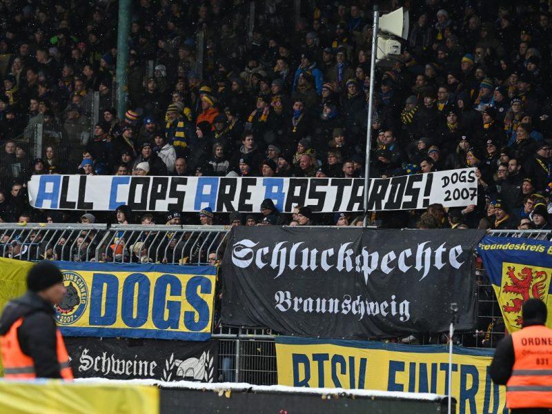 Die Fans von Eintracht Braunschweig zeigen Plakate gegen die Polizei.