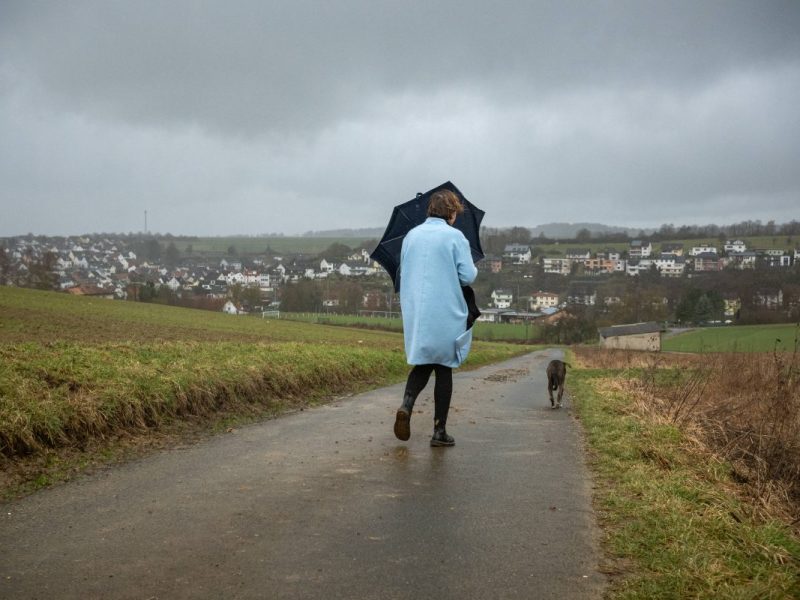 Frau mit Schirm und Hund