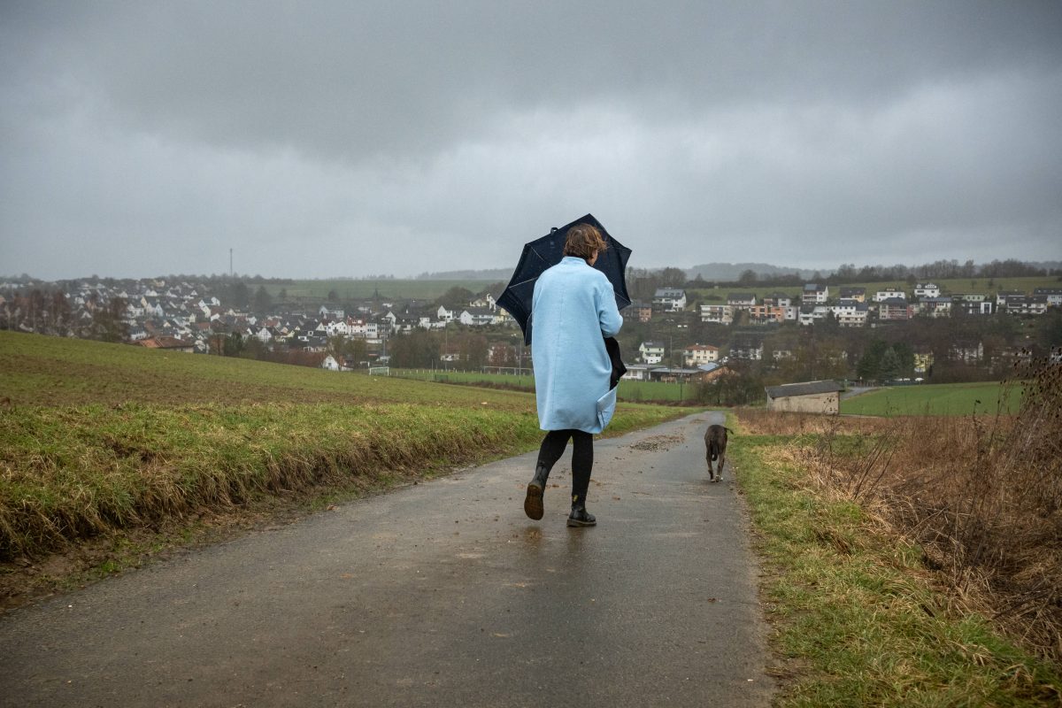 Frau mit Schirm und Hund