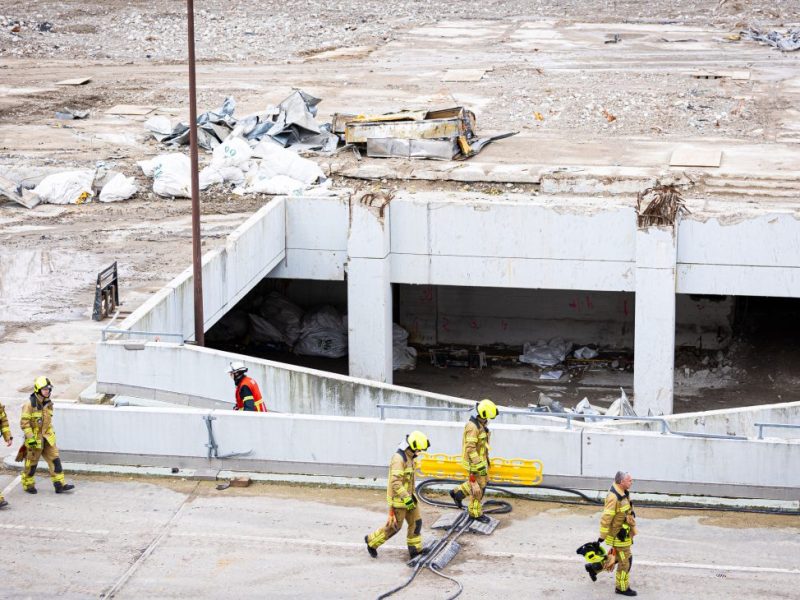 Einsatzkräfte der Feuerwehr gehen über das Gelände einer Großbaustelle im Stadtteil Mitte. Ein Bauarbeiter ist auf der Baustelle von einer Betonplatte verschüttet worden.