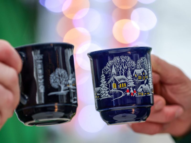Zwei Menschen stoßen mit Glühwein an