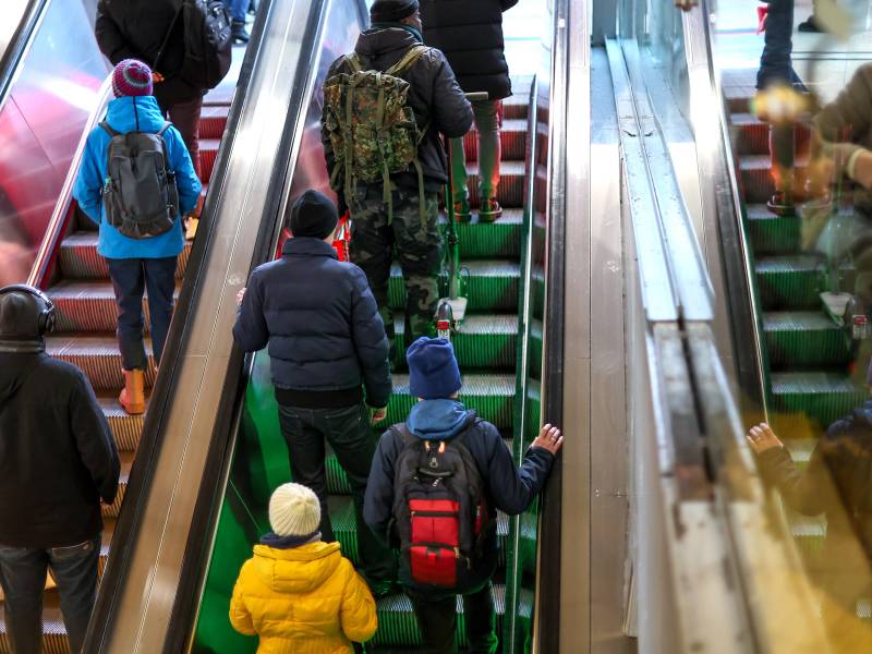 Passanten eilen auf einer Rolltreppe am Hauptbahnhof zu ihrem Gleis