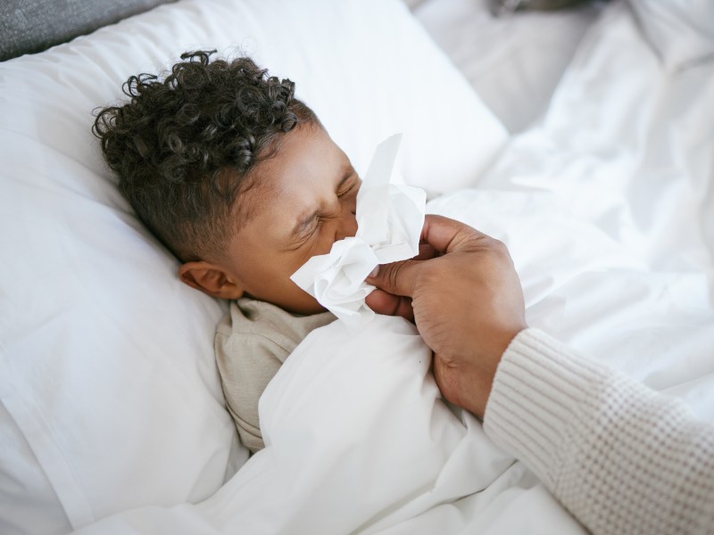 Kind mit Grippe erkrankt im Bett