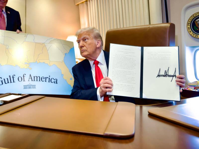 U.S. President Donald Trump, holds up the signed executive order renaming the Gulf of Mexico as the Gulf of America, during a flight on Air Force One to attend the Super Bowl,