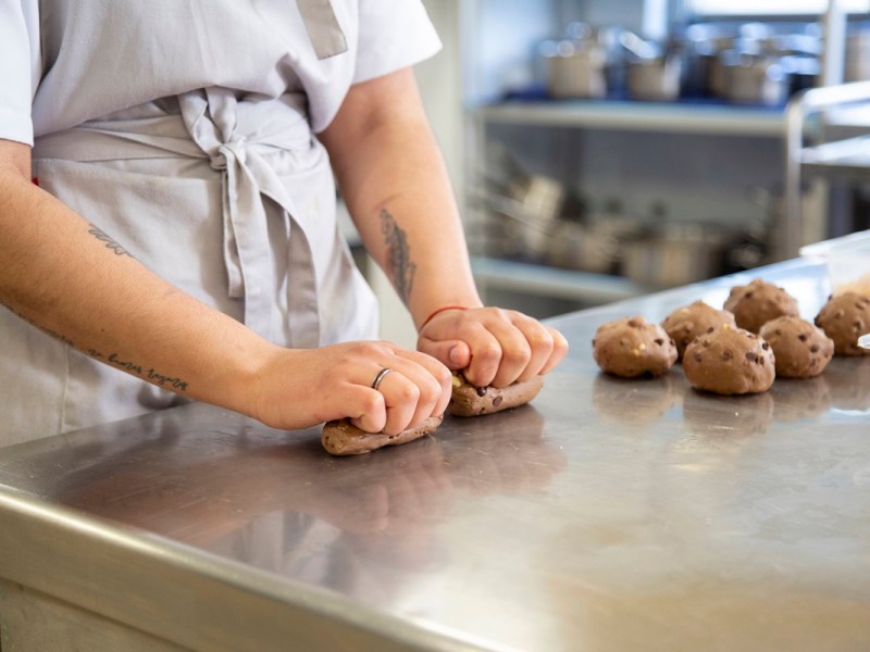 Person knetet Teig in Bäckerei