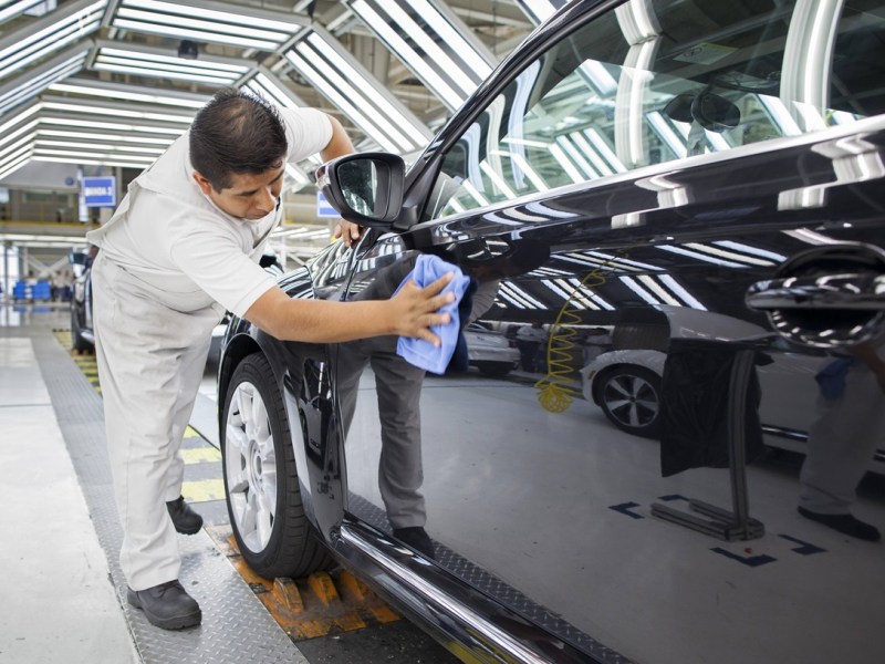 .Ein Mitarbeiter von Volkswagen de Mexico putzt in der Endkontrolle einen VW Golf.