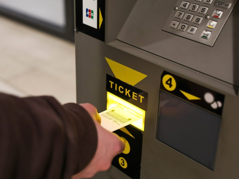 Nutzer gibt ein Parkticket in den Automaten ein, um die Parkgebühren zu begleichen.